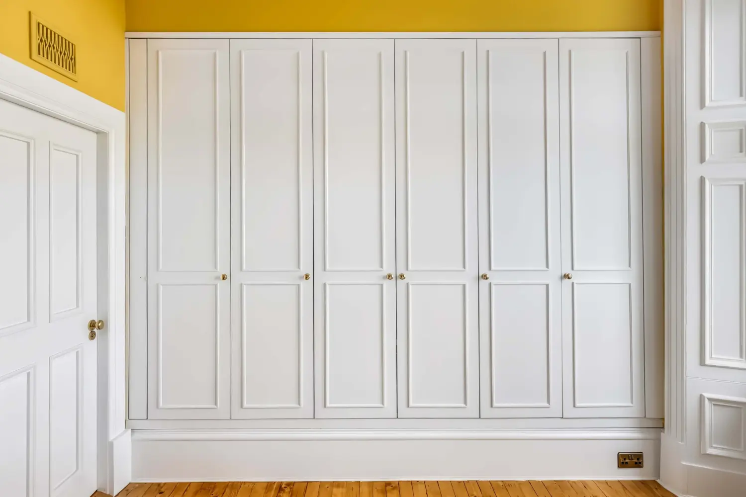 Fitted wardrobes in a yellow bedroom